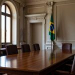 Sala de sessões do Ministério Público de Contas com mesa e bandeiras do Brasil