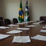 Sala de reuniões com bandeiras do Brasil e Rondônia representando decisão política do MDB