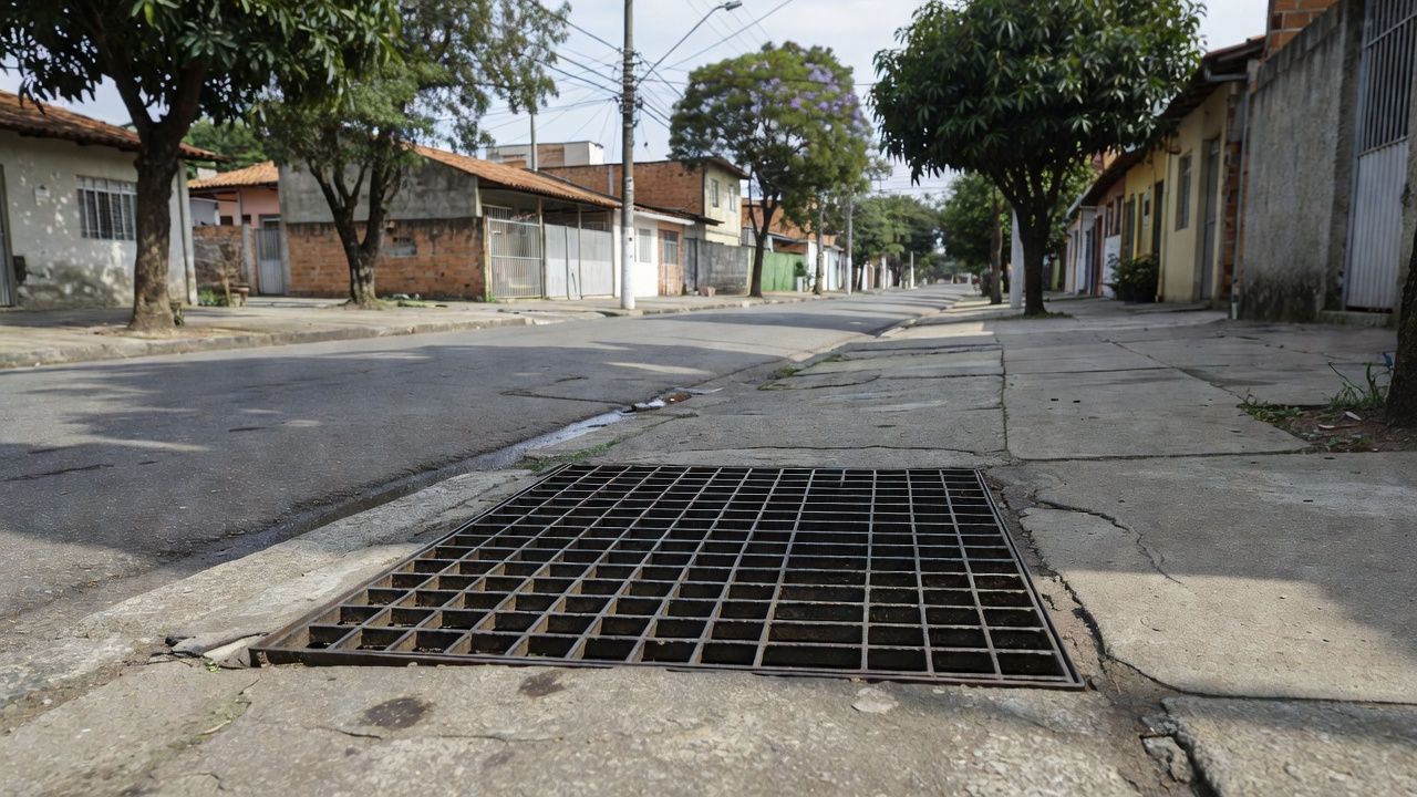Boca de lobo com grades de proteção em calçada no bairro Liberdade