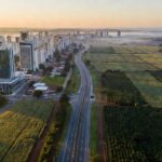 Paisagem de capital urbana e interior rural do Brasil conectados por estrada em estratégia eleitoral