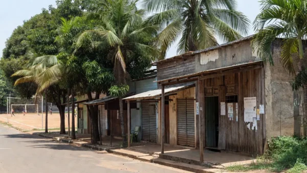 Rua comercial em Ariquemes com lojas e campo esportivo, agenda de campanha